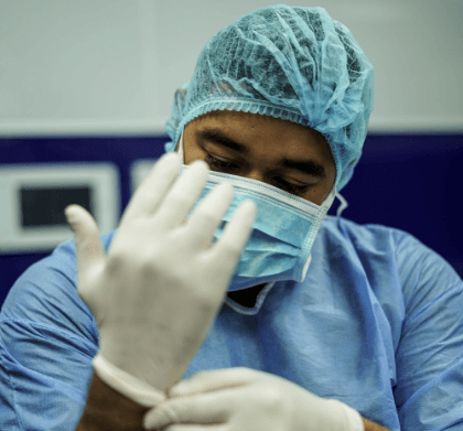 Doctor putting on protective gloves